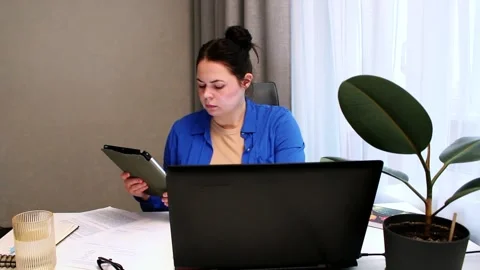 Young entrepreneur developing startup business plan at home. Determined woman Stock Footage 323082352