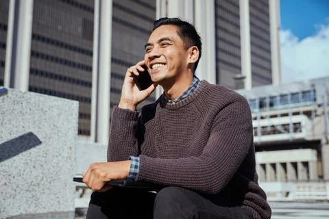 Young Entrepreneur Smiling While Talking on Mobile Phone in Urban Setting Stock Photos