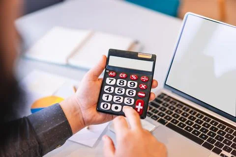 Young entrepreneur using a calculator while working Stock Photos