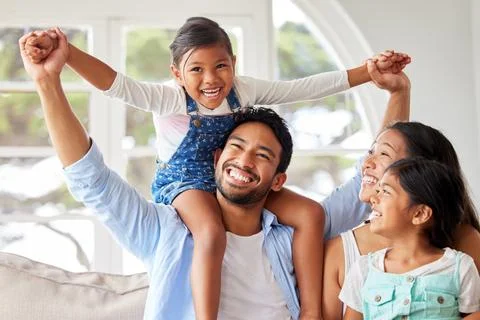 Young ethnic couple relaxing with their two daughters and enjoying family time Stock Photos