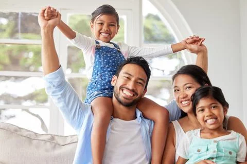 Young ethnic couple relaxing with their two daughters and enjoying family time Stock Photos