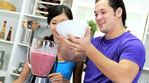 Young Ethnic Couple Using Blender Organic Fruit Drink Stock Footage
