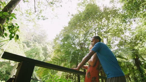Young, ethnically diverse couple enjoy the view and hug in the forest on a brigh Stock Footage 199458175