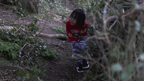 A young Eurasian boy walking carefully in the woods. Stock Footage 171098112