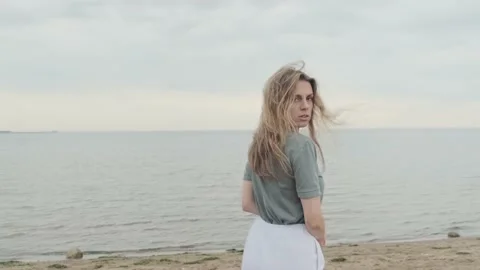 Young european girl walks in a sea coast, posing and looking at the camera Stock Footage