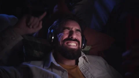 Young European man lying down looking and using his smartphone at room night Stock Footage 256040106