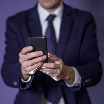 Young executive using a mobile phone. Closeup. Stock Photos