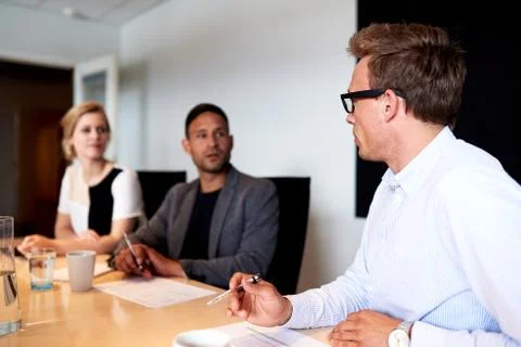 Young executives facing eachother during meeting Stock Photos