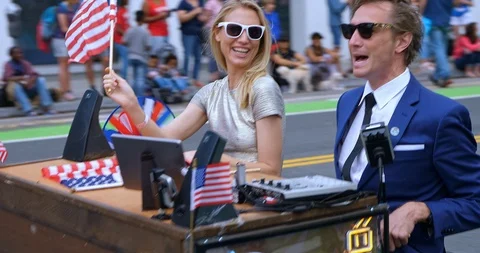 Young executives riding moving computer desk at at Independence Day parade, 4K Stock Footage 113579093
