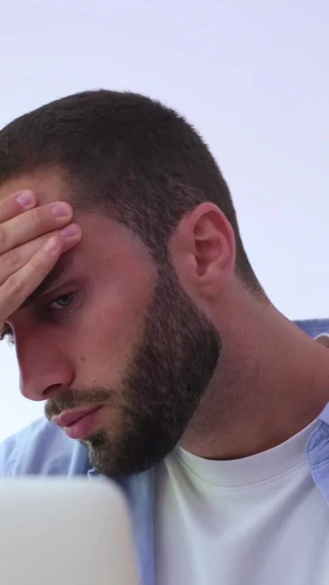 Young exhausted and overworked man feeling stressed and suffering from a severe Stock Footage 344757359