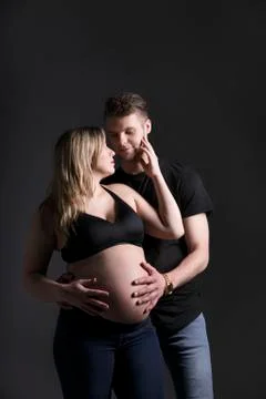 A young expectant couple looking at each other and the father is holding her bel Foto stock
