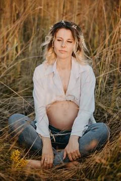 A young expectant mother in the third trimester of pregnancy is sitting in a  Stock Photos