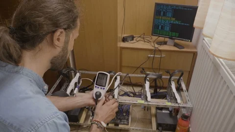 Young expert engineer examining with digital power meter cryptocurrency minin Stock Footage 102475075