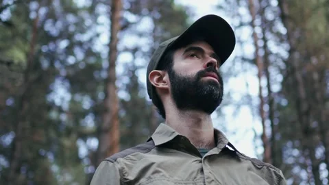 Young explorer man wearing cap looking away in the forest. Park ranger during a Stock Footage 241737396