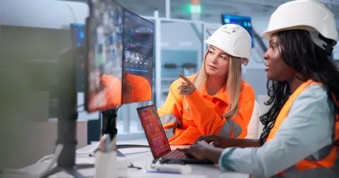 Young Factory Operator And Engineer Discuss Digital Control System On Laptop. Stock Photos