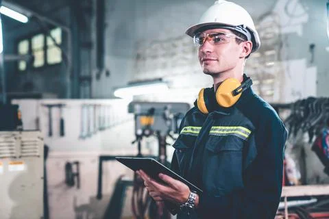Young factory worker using adept tablet computer in a workshop building Foto stock
