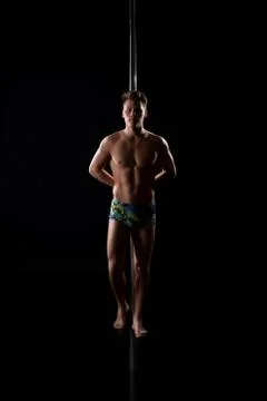 Young fair athletic man posing in studio by pylon Stock Photos