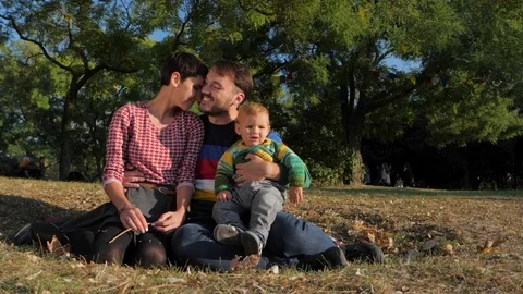 Young family with Baby Boy Enjoying Sunny evening in the Park. Slow Motion Stock Footage