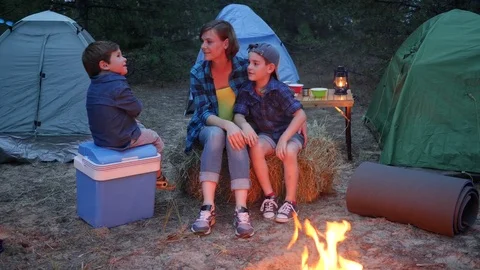 Young family in background tents and trees, family weekend in forest, mother and Stock Footage