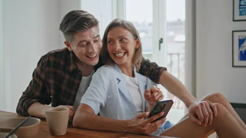 Young family browsing smartphone in kitchen closeup. Girlfriend looking mobile Stock Footage 333136786