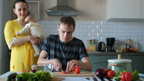 Young family with cute baby cooking dinner Stock Footage