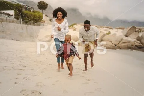 Young family enjoying a day at the beach Stock Photos