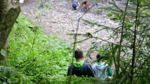 Young family going down to small waterfall in forest Video stock 146308239