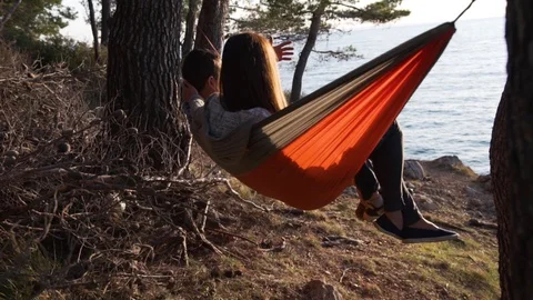 A young family on a hammock meets the sunset Stock Footage 124731553