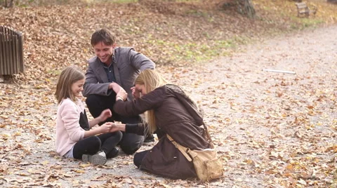 Young family having fun while they sitting on pathway in the park Stock Footage 59553772