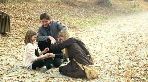 Young family having fun while they sitting on pathway in the park Stock Footage 59553779