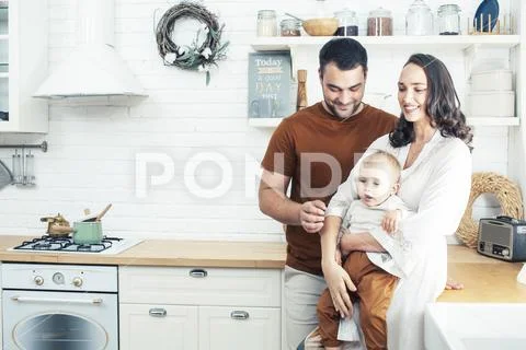 Young family with little cute son on kitchen in morning happy smiling, lifestyle Stock Photos