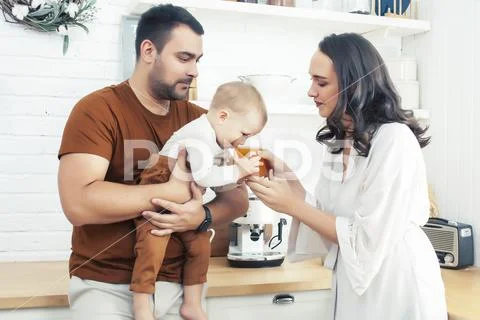Young family with little cute son on kitchen in morning happy smiling, lifestyle Stock Photos