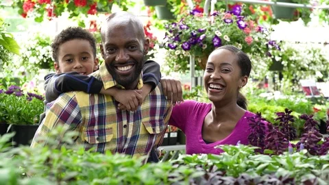Young family looking at camera while standing in a greenhouse 動画素材 83390236