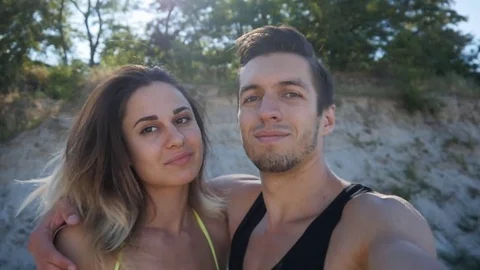 Young family man and woman doing selfie in summer on the beach at sunset. Stock Footage