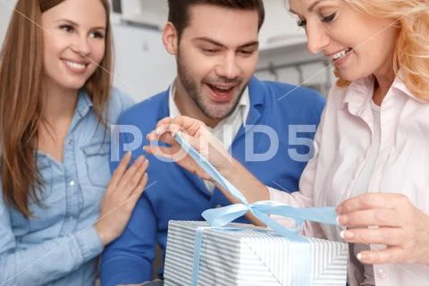 Young family with mother-in-law at home weekend openning birthday gif close-up Stock Photos