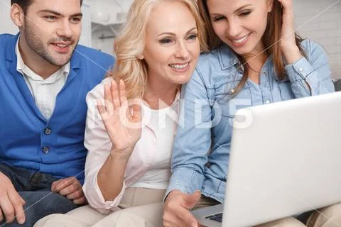 Young family with mother-in-law at home weekend video chat close-up Stock Photos
