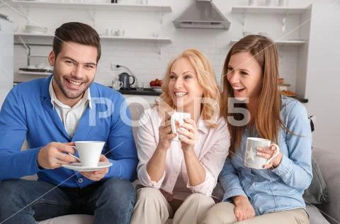 Young family with mother-in-law at home weekend drinking Stock Photos