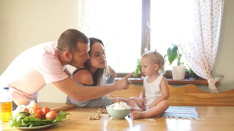 A young family spends time in the kitchen, dad is putting flour on the nose of Stock Footage 80275024