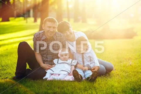 Young family with two children walking in a summer park Stock Photos
