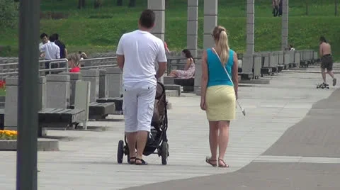 Young family walking in the park with a pram Stock Footage