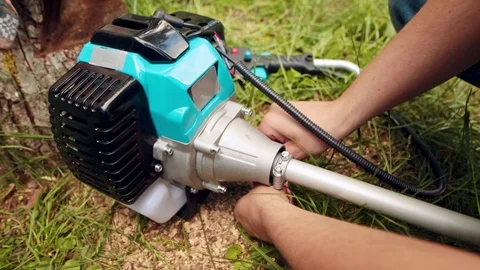 Young farmer assembles brush cutter engine. Video stock 91444445