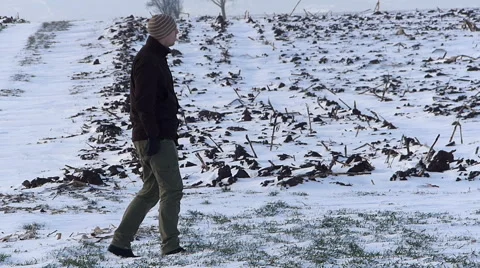 Young farmer checking on wheat in winter Stock Footage 49104197