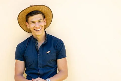 Young farmer with hat, smiling at the camera on white background. Stock Photos