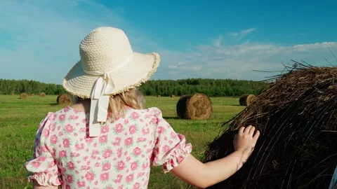 A young farmer in a hat stands in a field admiring the landscape. Stock Footage 315737854