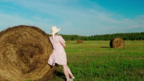 A young farmer in a hat stands in a field admiring the landscape. Stock Footage 315737862
