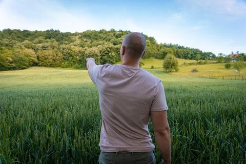 Young farmer pointing at something in the distance Stock Photos