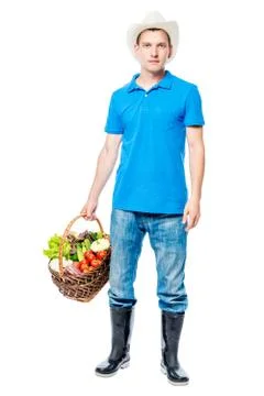 Young farmer portrait with a basket of vegetables on a white background in .. Stock Photos
