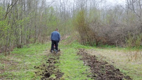 Young farmer working in the field with a walking tractor . Concept ecology Stock Footage 111812153