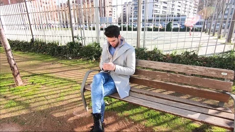 Young fasion man sitting on the park bench. Stock Footage
