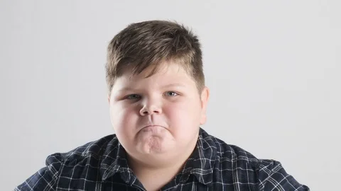 Young fat boy shows anger, aggression and hatred Stock Footage 82269353